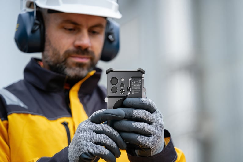A16PM_Worker-Looking-At-Xshielder-Device